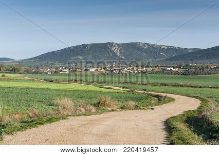 Small hamlet in an agricultural landscape in La Mancha, Ciudad Real Province, Spain. In the background can be seen the Toledo Mountains