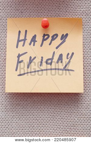 Adhesive note with Happy Friday text on a cork bulletin board