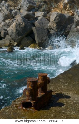 Gammel mole med en rusten pullert