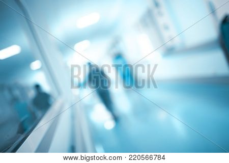 Obscure figure walking through the hospital corridor, unfocused background.