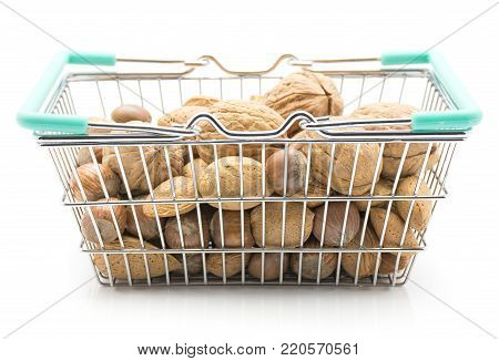 Nuts mix (walnut, hazelnut and almond) in a shopping basket isolated on white background