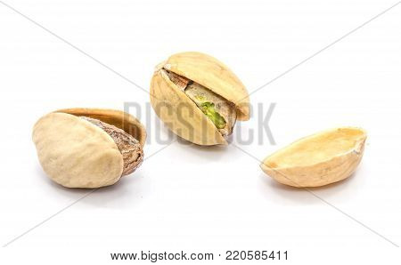 Two whole open pistachio nuts, one shell half isolated on white background