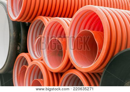 Construction orange and black plastic pipes in construction base