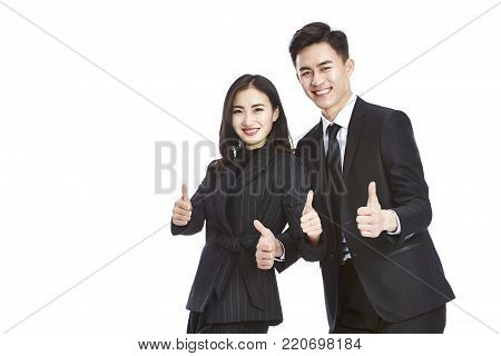 studio shot of two young asian corporate executive, businessman and businesswoman, showing the two-thumbs-up sign, looking at camera smiling, isolated on white background.