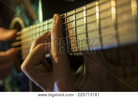 Man with guitar, male hand playing on acoustic guitar. Close-up.