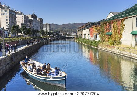 Otaru, Japan - October 19, 2017 : Unknown tourists on Otaru canal cruise, bright beautiful autumn day.