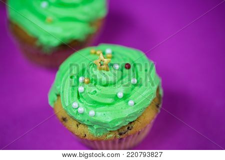 green muffin with buttercreme, on pink background