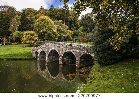 Stone vintage bridge in a public English park.