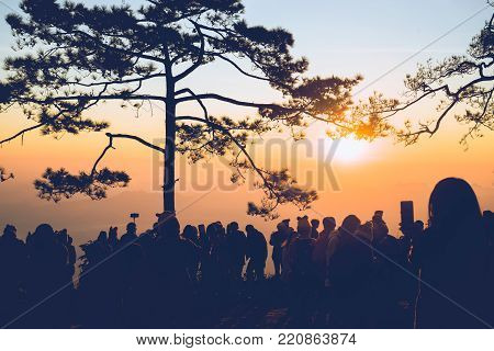 People watching Sunrise in the morning. Tourists travel relax in the holiday. photograph sunrise in the morning among people. Thailand