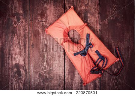Old vintage life vest on a wooden background