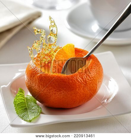Tangerine mousse dessert served in the skin of the fruit with spun sugar.