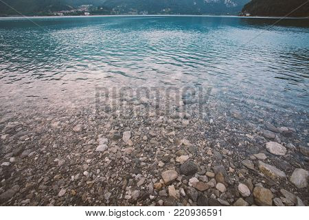 Italy view of the bottom of the beach mountain lake lago di ice in summer in cloudy weather.