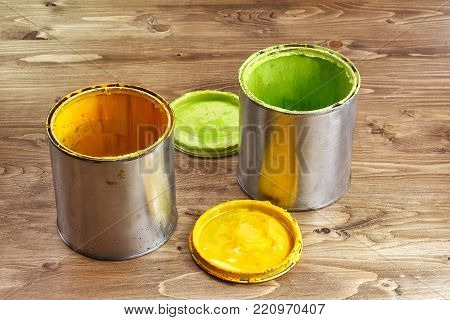green paint can with a brush on a rustic wooden background