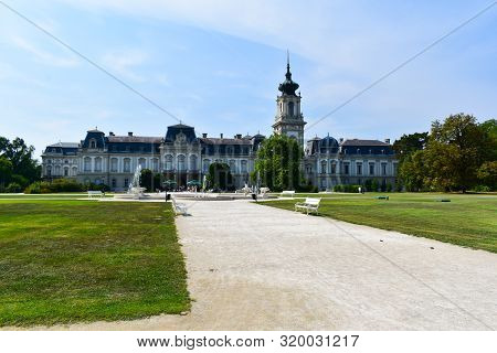 Keszthely, Hungary - August 28, 2019: Festetics Castle With Garden And Fountain, White Benches. Heli