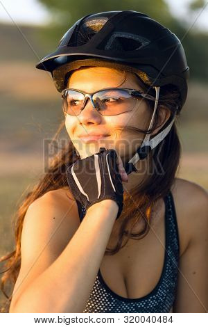 Girl On A Mountain Bike On Offroad, Beautiful Portrait Of A Cyclist At Sunset, Fitness Girl Rides A 