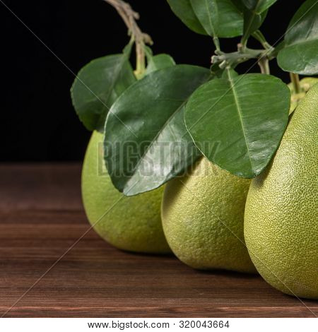 Fresh Peeled Pomelo, Grapefruit, Shaddock With Green Leaves On Dark Wooden Plank Table. Seasonal Fru