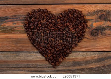 Coffee Beans In Heart Shape. Heart Shape Made From Roasted Coffee Beans On Rustic Wood, Top View.