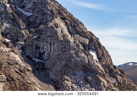 Rocks In The Mountains Against The Blue Sky.