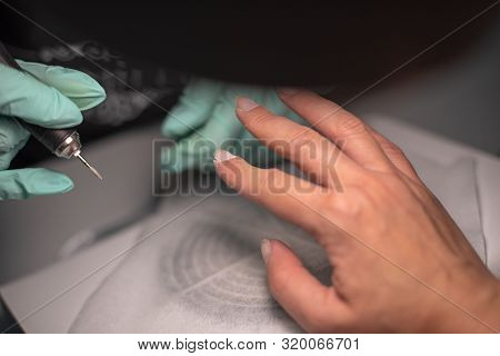 A Manicure Hand With A Nail Lies On A Manicure Hand In Blue Hygienic Gloves.hands On The Manicure Of