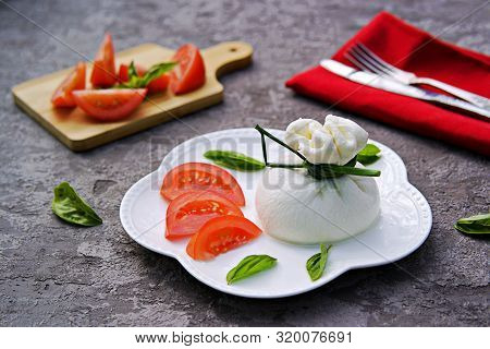Fresh Farm Cheese Burrata On A White Curly Plate On A Gray Concrete Background. Served With Chopped 