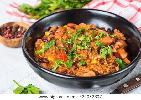 Chili Con Carne From Meat, Beans And Vegetables In Black Plate On Stone Table. Traditional Mexican F