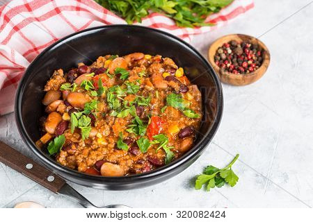 Chili Con Carne From Meat, Beans And Vegetables In Black Plate On Stone Table. Traditional Mexican F
