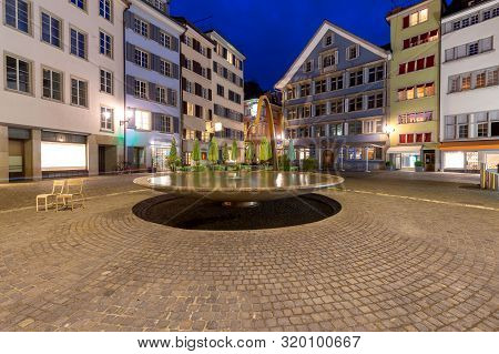 Round Fountain On The Munsterhof Square At Night. Zurich. Switzerland.