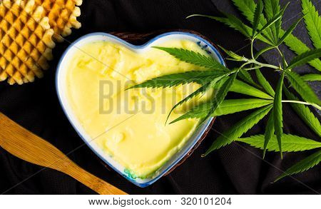 Butter With Cannabis Plant In A Heart Shape Bowl Top View
