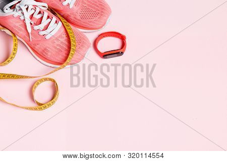 Fittnes Sport Composition With Pink Sneakers, Smart Bracelet, Measuring Tape On Pink Background.