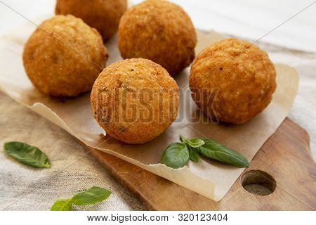 Homemade Fried Arancini With Basil On A Rustic Wooden Board, Side View. Italian Rice Balls. Close-up