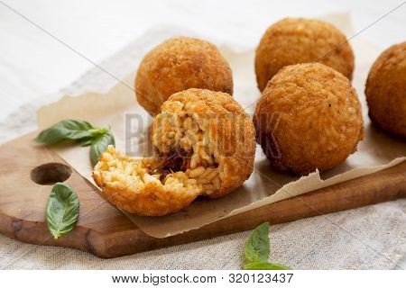 Homemade Fried Arancini With Basil On A Rustic Wooden Board, Side View. Italian Rice Balls. Close-up
