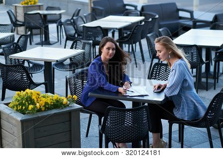 Two Cooperative Workers Are Disscussing New Project Outside Office, At Caffeteria At Nice Summer Day