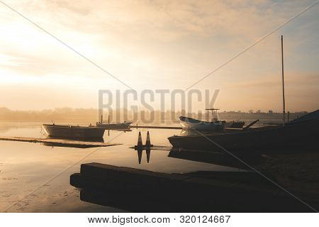 Sailing Boats On A Lake During A Frosty Winter Sunrise