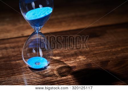 Time Passing, Deadline, Urgency Concept. Time Management. Blue Hourglass On Wooden Background. Copy 