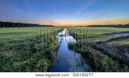 Sunset Landscape Of Lowland River Koningsdiep In The Netherlands