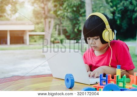 Asian Girl And Boy Wear Headphone And Enjoy Music By Using Internet And Labtop, Concept For Kid And 