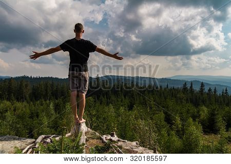 Young Man Meditating, Stretching Shoeless On Tree Stump, Sumava National Park, Czech Republic