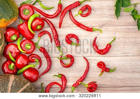 Autumn Harves Vegetables. Pumpkin, Red And Green Hot Peppers On A Wood Background. Thanksgiving Rust