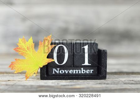 All Saints Day. Wooden Calendar And Yellow Autumn Leaf