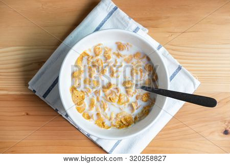Healthy Breakfast With Corn Flakes And Milk On Wooden Table, Top View