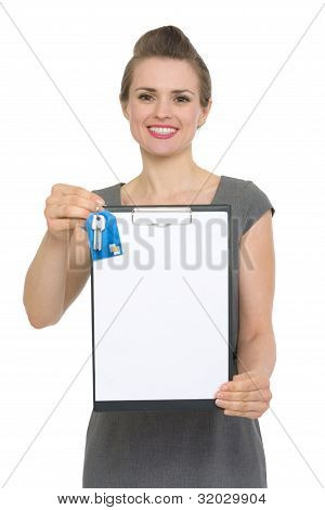 Happy Female Realtor Holding Blank Clipboard And Keys Isolated