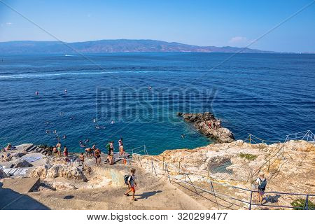 Hydra, Greece - 16 August 2019: Beach Spilia With Bar. Beautiful Greek Landscape Of Harbour Hydra To