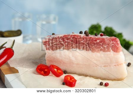 Composition With Pork Fatback And Spices On White Table Against Blue Background