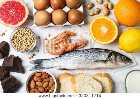 Flat Lay Composition Of Different Products On White Marble Table. Food Allergy Concept