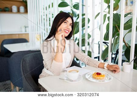people, leisure and inspiration concept - happy asian woman with coffee, dessert and notebook daydreaming at cafe