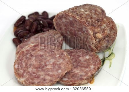 Cooked Cotechino Salame With Beans Served On A Plate
