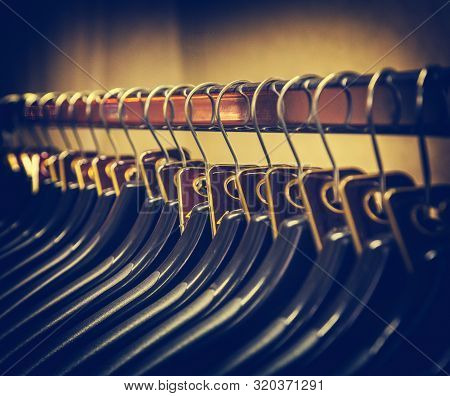 Lot Of Plastic Black Hangers On The Bar. Concept Store, Sale, Design, Empty Hangers.
