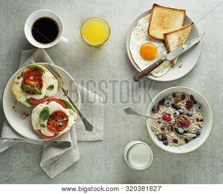 Breakfast Served With Oatmeal And Fruits, Mozzarella Sandwich And Fried Egg With Bread On Table Top 