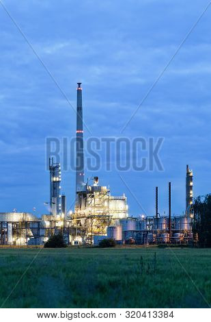 View On Illuminated Operational Chemical Plant In Twilight