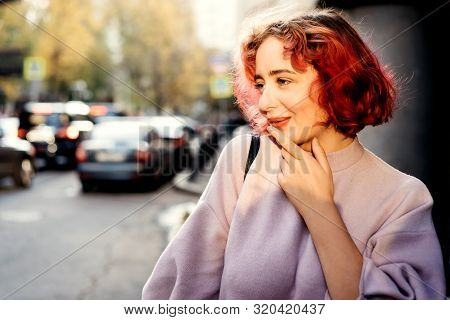Beautiful Woman With Red Dyed Hair And Sunny City Background.